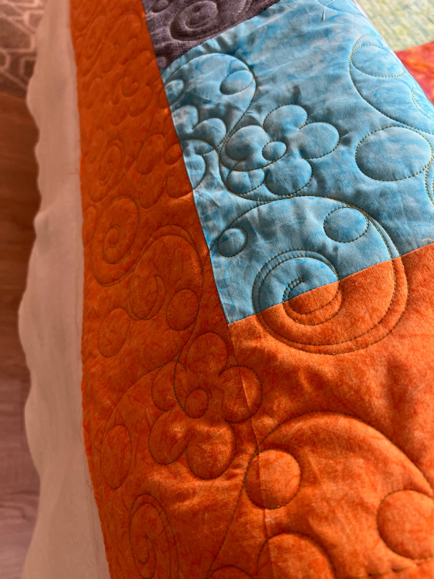 Long arm Quilting for Brenda Hays - Batik quilt with orange border, quilted with daisies and glide, prickly pear thread