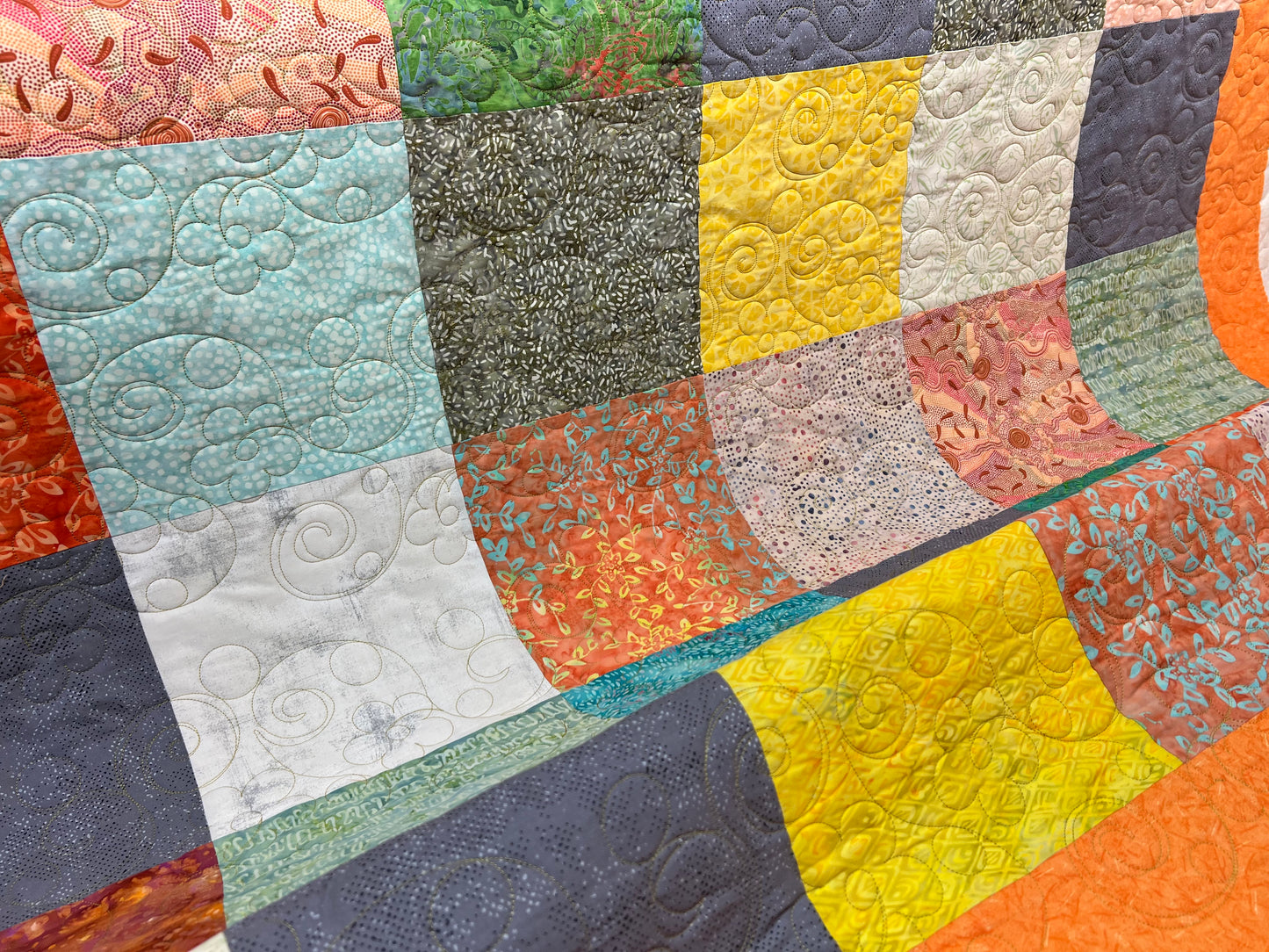 Long arm Quilting for Brenda Hays - Batik quilt with orange border, quilted with daisies and glide, prickly pear thread