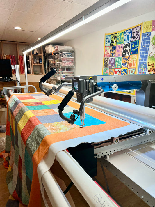 Long arm Quilting for Brenda Hays - Batik quilt with orange border, quilted with daisies and glide, prickly pear thread